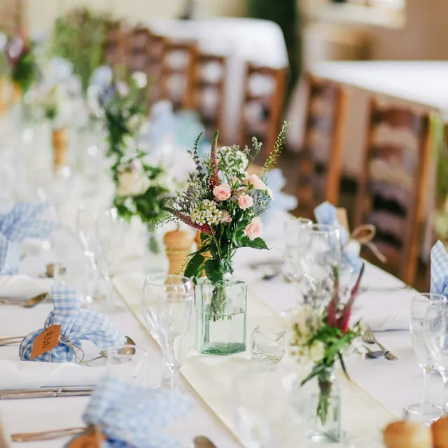Recepción de boda en jardín con mesas largas y luz cálida