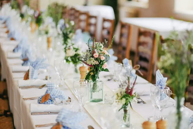 Recepción de boda en jardín con mesas largas y luz cálida
