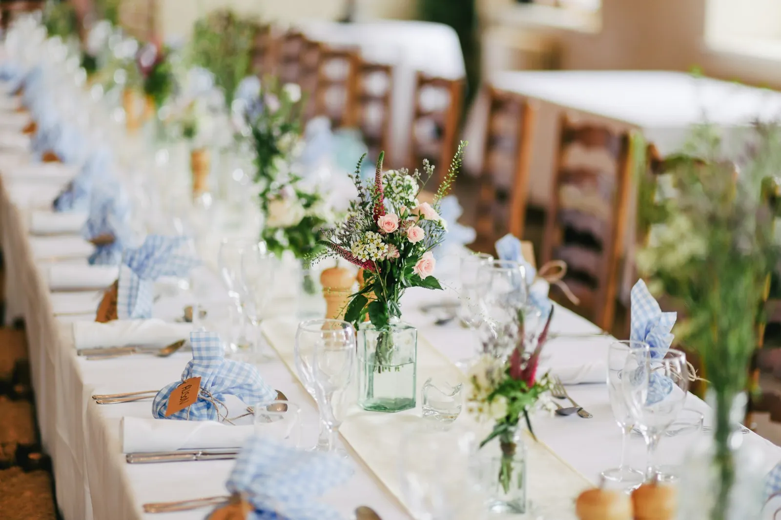 Recepción de boda en jardín con mesas largas y luz cálida
