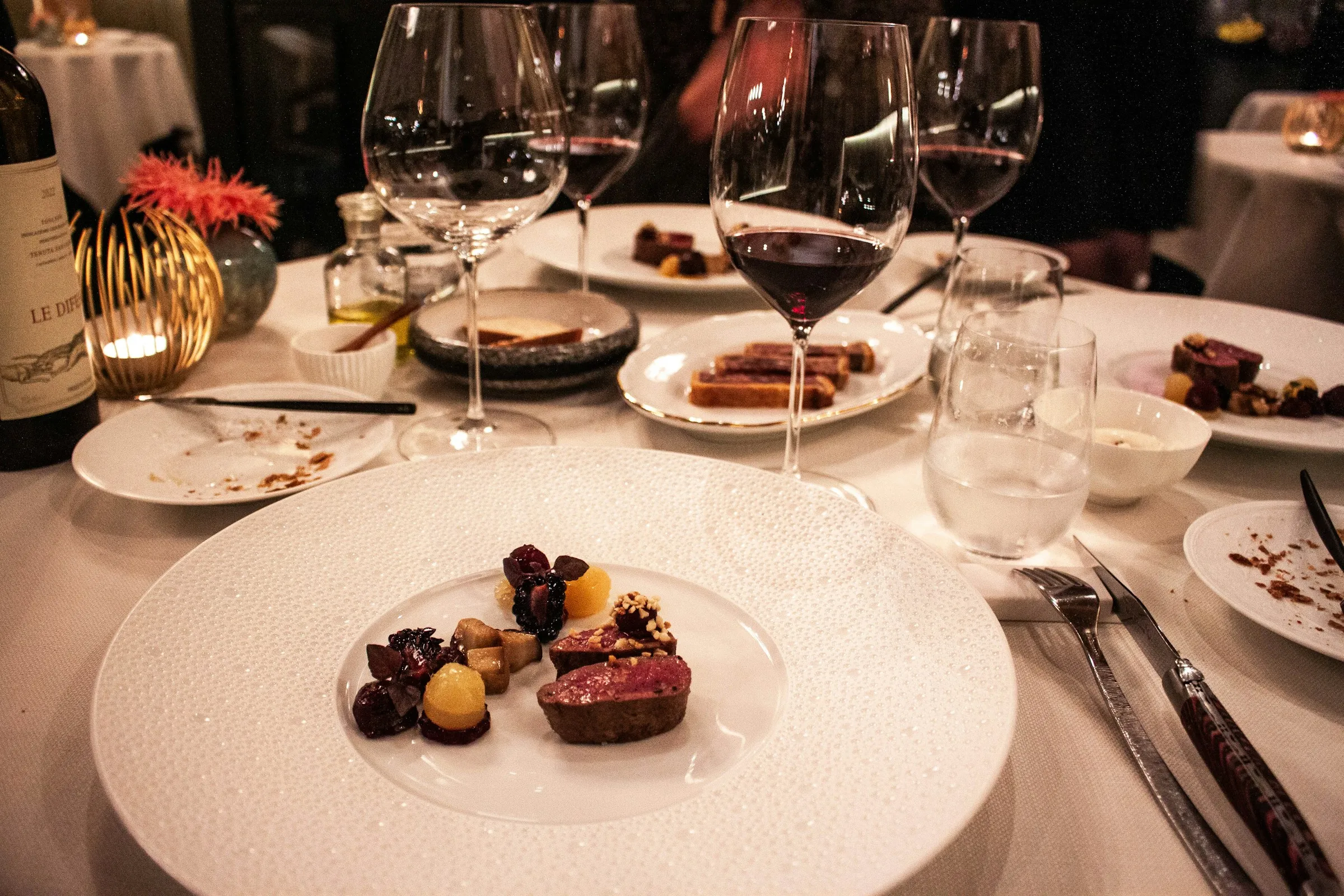 Mesa montada con vajilla de cristal y servicio de cena