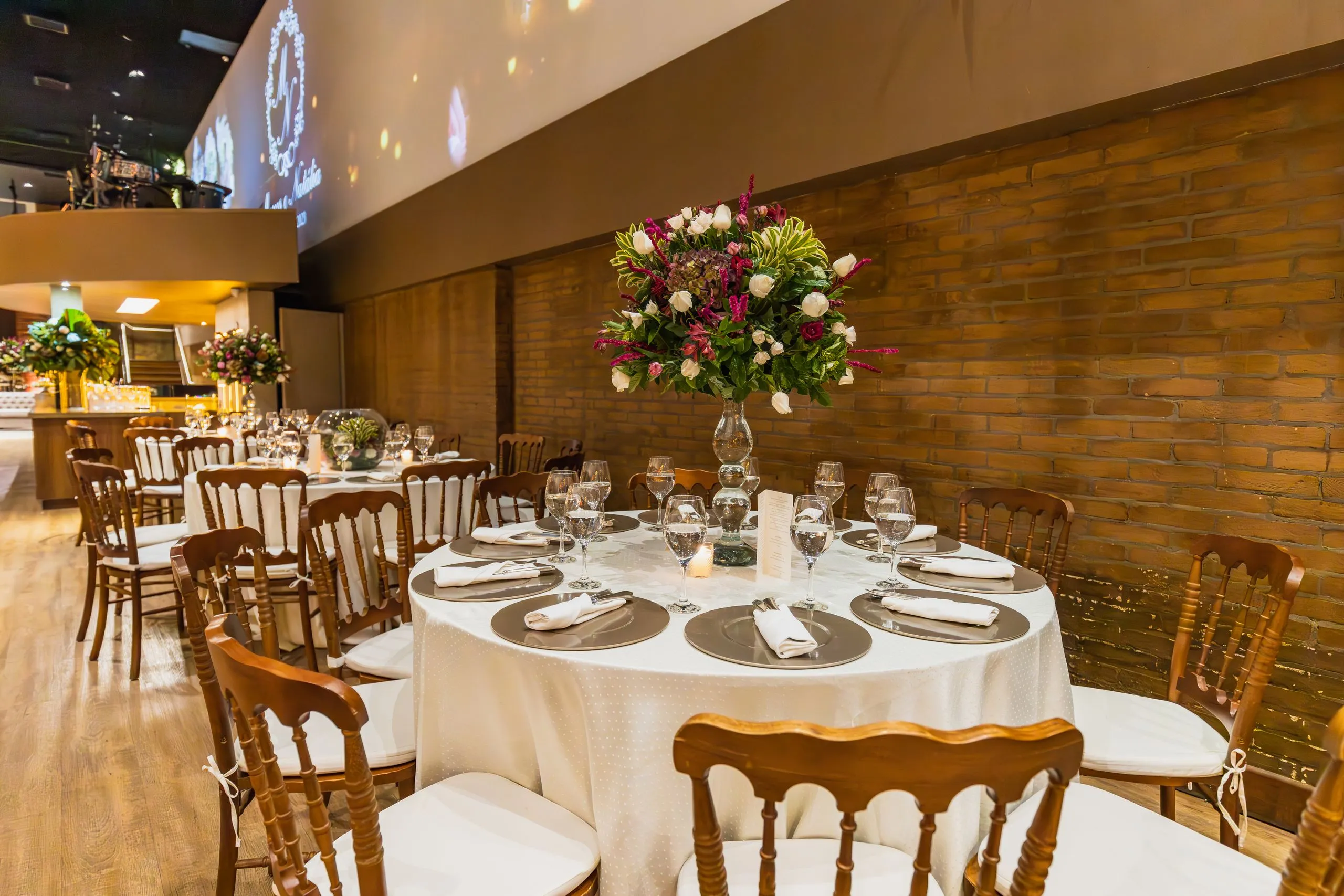 Banquete con velas, vajilla de plata y sillas de madera